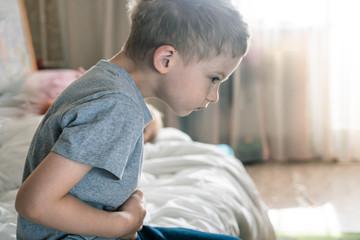 abdominal pain in a preschool child. poisoning in children. the boy holds his hands to the...