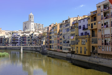 Fototapeta na wymiar Girona's skyline with cathedral and bridge over the river landmarks on a blue Sunny day