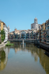 Girona's skyline with cathedral and bridge over the river landmarks on a blue Sunny day