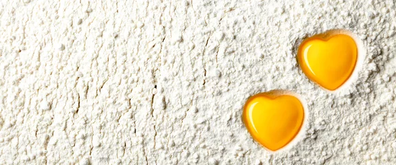 Zwei gelbe herzförmige Eigelbe auf weißem Mehlhintergrund - Liebe, Konzept zu backen © Philip Steury