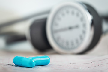 Medical pills on the background of ECG, cardiogram and cardiac gauge.  Diagonics, prevention and...