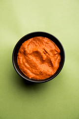 Peri Peri Sauce in a bowl, originally from portugal, it's a hot sauce made using piri piri or African bird's eye chillies.  selective focus