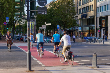  People or cyclists ride bicycle on the bicycle lanes cross at pedestrian crossing at Königsallee...