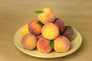Ripe peaches in a plate on a wooden background. Close-up peaches Healthy food concept, plant background, natural eco-products, organic food, vegetarian, vegetables, raw, festival food