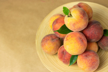 Ripe peaches in a plate on a wooden background. Close-up peaches Healthy food concept, plant background, natural eco-products, organic food, vegetarian, vegetables, raw, festival food