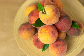 Ripe peaches in a plate on a wooden background. Close-up peaches Healthy food concept, plant background, natural eco-products, organic food, vegetarian, vegetables, raw, festival food