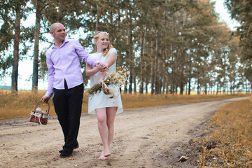 Fototapeta premium Just married lovers walking in a field in autumn day