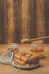 Wafers. Homemade pastries. Wafers with honey and walnut with a sieve on a wooden table.