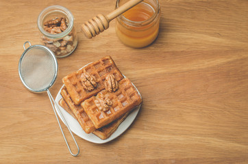 Wafers. Homemade pastries. Wafers with honey and walnut with a sieve on a wooden background. Top view and copy space