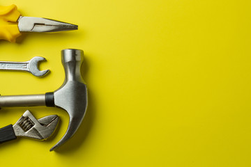 Metal tools on yellow background, close up