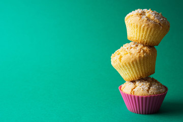 Tasty baked muffins on a green background, minimalism, a place for an inscription