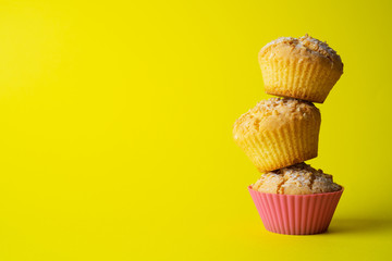 Tasty baked muffins on a yellow background, minimalism, a place for an inscription