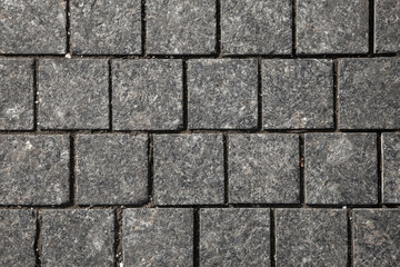Abstract background of gray cobblestone pavement,close-up, top view.
