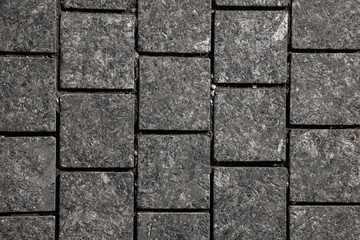Abstract background of gray cobblestone pavement,close-up, top view.