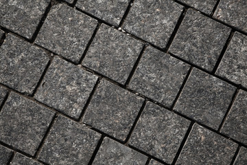 Abstract background of gray cobblestone pavement,close-up, top view.