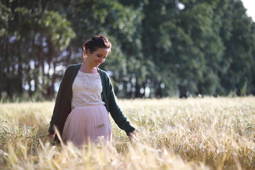 A young mother walk in wheat fields