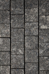 Abstract background of gray cobblestone pavement,close-up, top view.
