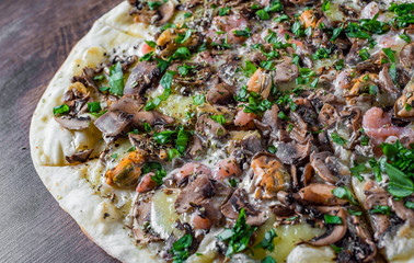 Seafood Pizza - Marinara. Pizza with Mozzarella cheese, shrimps, mussels, mushrooms, tomato sauce, pepper. Italian pizza on wooden table background