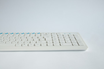 white computer keyboard lies on a table on a white background