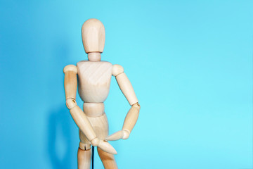 yellow wooden maniken is dancing and doing poses on blue background