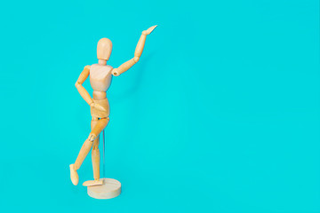 yellow wooden maniken is dancing and doing poses on blue background