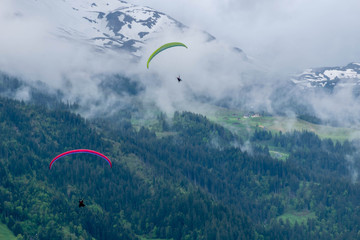 Two sky divers in the sky in Alps mountains, Switzerland