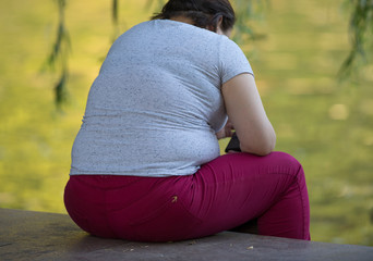 fat girl sitting by the water