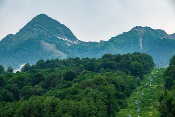 The green slope of the mountain with the cable cars