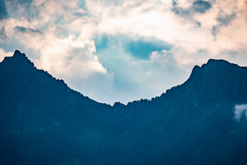 Sunset sky over high green mountain with rocks