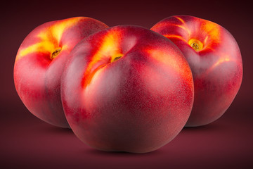 Three ripe peaches on a red(scarlet) background. Full depth of field.