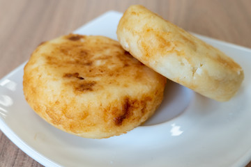 Two pancakes of cottage cheese on a white plate. Russian national dish for Breakfast