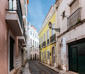 Fototapeta na wymiar Quiet street with rails in the old city of Lisbon summer clear sunny day