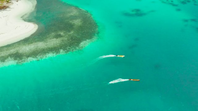 Motor boats on the surface of the lagoon with turquoise water, top view. Summer and travel vacation concept. Balabac, Palawan, Philippines.
