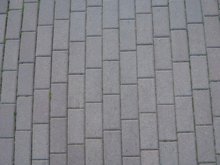 Details of gray brick stone pavement on the street road. Gray stone blocks background and texture,...