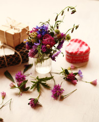 a bouquet of summer flowers  and gifts on the white background