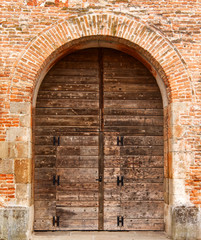 Ancient wooden door and stone gate in Italy