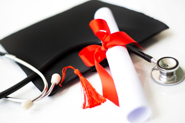 Black graduation cap, degree and stethoscope