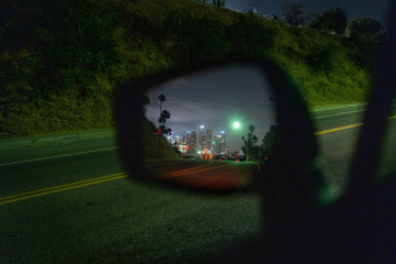 Los Angeles downtown skyline at night reflected in side car mirror