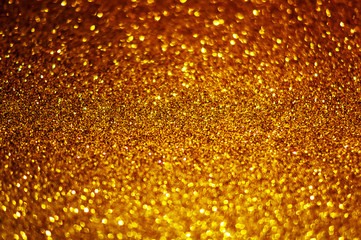 Festive abstract gold glitter texture background with shiny sparkle. Colorful defocused background with glittering and sparkling spots. Suitable for christmas,new year,chinese new year and designs