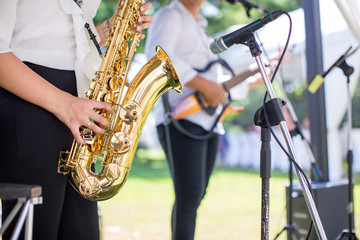 Gorgeous saxophonist lady is playing saxophone in wedding ceremony. musician woman. attractive woman and music instrument . classical and romantic happiness events. image for objects and copy space.