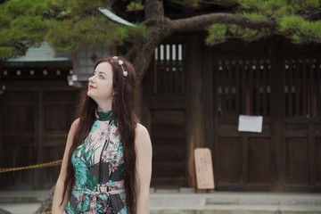 Brunette caucasian hippie girl smiling in Japanese courtyard