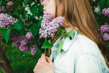girl holding a sprig of purple lilacs, close-up