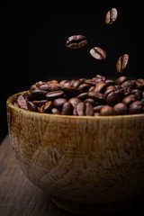 Coffee bean a wooden bowl on dark background