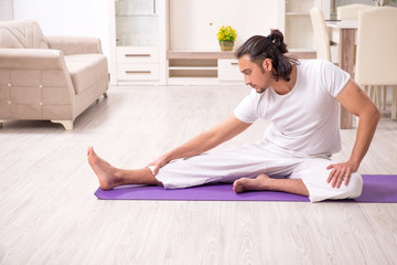 Young man doing physical exercises at home