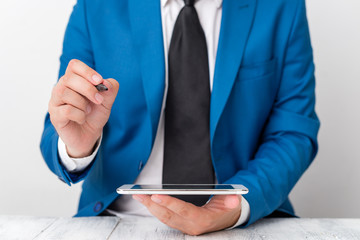 Businessman pointing with pen in empty copy space.