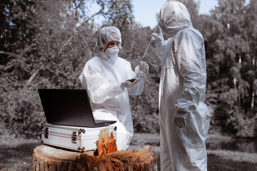 Ecological problem. Pollution. Examine soil. Scientist in protective mask and suit taking water...