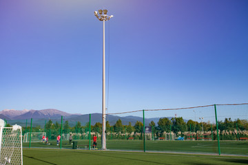 Training football field. Summer stadium and football game concept. Football field lighting. Lighting pillar with led technology.