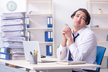 Young male employee unhappy with excessive work
