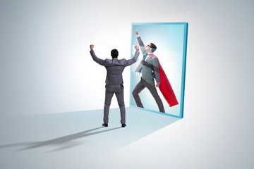 Businessman seeing himself in mirror as superhero