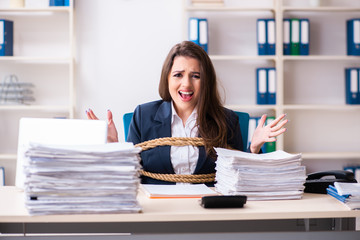 Young beautiful employee tied up with rope in the office